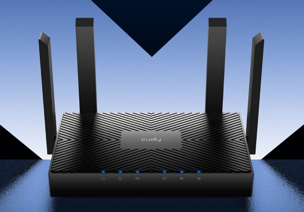 Router CUDY WR3000 Widok routera z czterema antenami skierowanymi pionowo. Obudowa ma ciemny kolor i geometryczny wzór na górnej powierzchni. Z przodu widoczne są podświetlane ikony sygnalizacyjne, opis