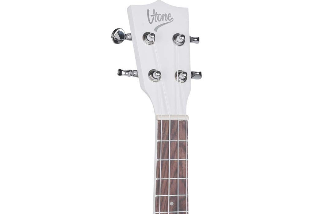 Na obrazie widoczna jest główka białego ukulele z logo \'V-TONE\'. Instrument ma cztery klucze do strojenia i drewnianą podstrunnicę z progami.