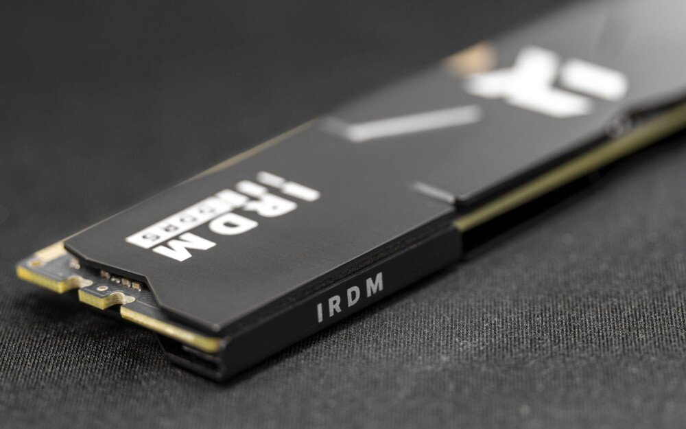 Pamięć RAM GOODRAM IRDM DDR5 Pojedynczy moduł pamięci RAM w czarnym radiatorze leżący na ciemnym tle z widocznym złączem krawędziowym i białym logo producenta, korekcja błędów, stabilność pracy