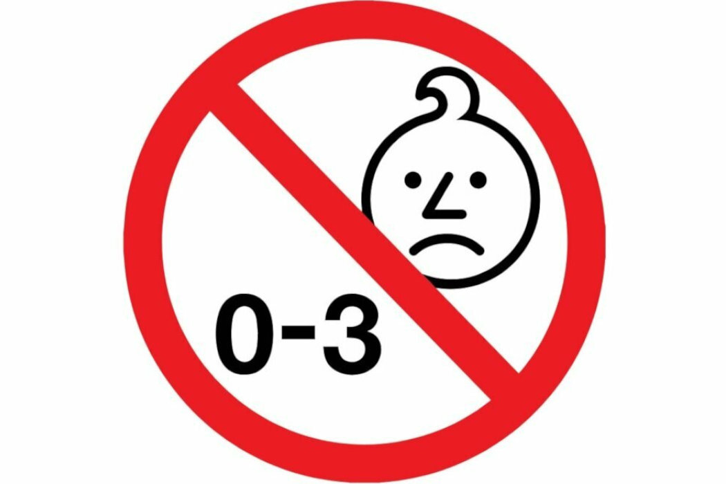 Czarno-biały symbol smutnej twarzy dziecka z zakręconym kosmykiem włosów, przekreślony czerwoną linią. Pod spodem napis \'0-3\'.