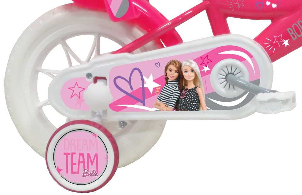 Fragment roweru dziecięcego z różową ramą i białymi kołami. Na osłonie łańcucha widoczne są postacie dwóch lalek oraz napis \'DREAM TEAM Barbie\' na bocznym kółku pomocniczym.