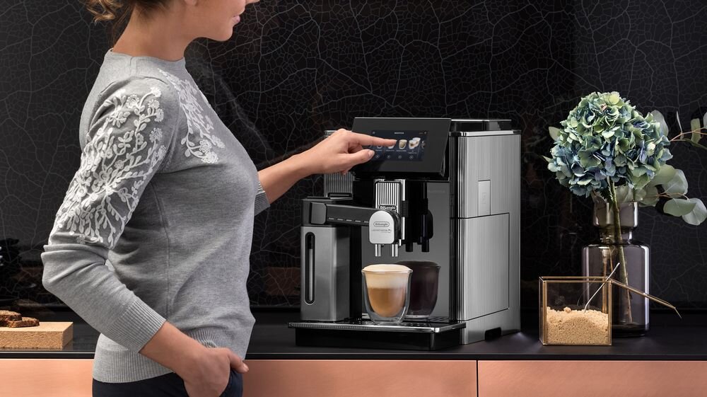 DELONGHI Maestosa - ekspres na meblach, kobieta przygotowuje napój