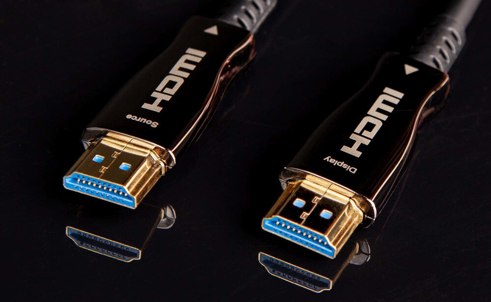Kabel optyczny HDMI - HDMI CLAROC 60 m technologia AOC żyły światłowodowe transmisja TMDS, kabel leżący na czarnym blacie, końcówki