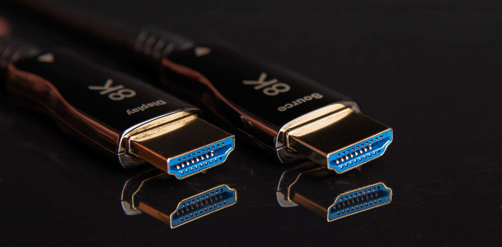 Kabel optyczny HDMI HDMI CLAROC 50 m HDMI 2.1 8K 60Hz 4K 120Hz Ultra High Speed, kabel leżący na czarnym blacie, końcówki