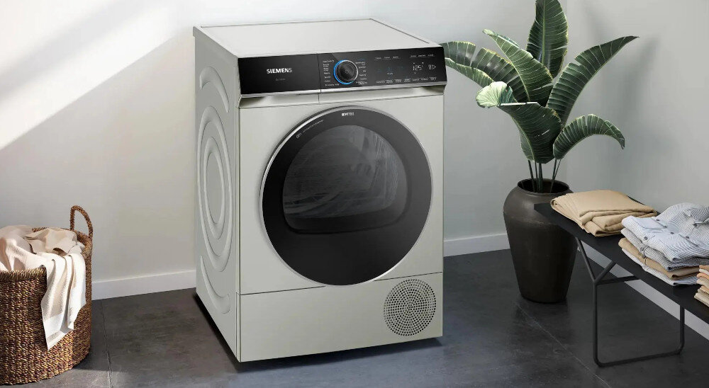 Suszarka SIEMENS WQ46B2CXPL zdjęcie lifestyle wizualizacja front kolor srebrny panel sterowanie pokrętło drzwiczki łazienka kosz na pranie ubrania roślina Automatyka suszenia