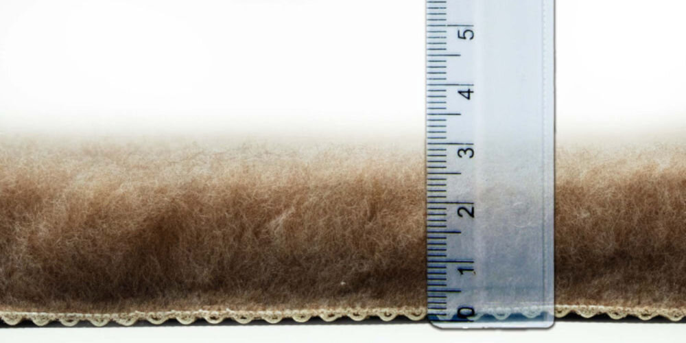 Legowisko uniwersalne BUBA Dry Bed A23 Beżowy 100 x 75 Zbliżenie na grubość beżowego dywanika mierzoną przezroczystą linijką. Włosie ma około 2,5 do 3 centymetrów wysokości.