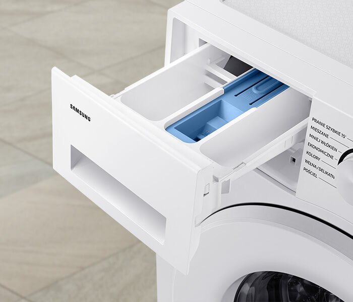 Zdjęcie przedstawia otwarty dozownik pralki z widocznymi przegródkami na detergenty. Na dozowniku widnieje logo \'SAMSUNG\', a obok znajdują się napisy: \'PRANIE SZYBKIE 15’\', \'MIESZANE\', \'MINI ZAŁADUNEK\', \'EKOLOGICZNE\', \'KOLOROWE\', \'WEŁNA/DELIKATNE\', \'POŚCIEL\'.