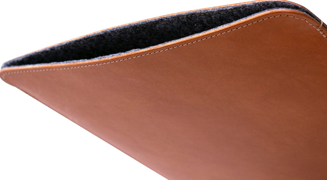 Brązowe etui na laptopa z widocznym miękkim, ciemnym wnętrzem. Etui ma gładką powierzchnię i staranne szwy na krawędzi.