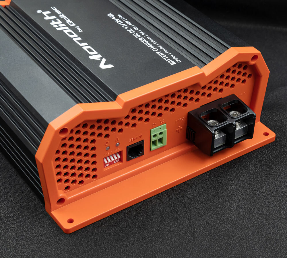 Inteligentna ładowarka QOLTEC Monolith 52480 do akumulatorów LIFEPO4 AGM GEL 12V-12V 40A 500W, zasilanie, prąd, ładowanie, energia, na czarnym tle zbliżenie na ładowarkę i jej porty ładowania