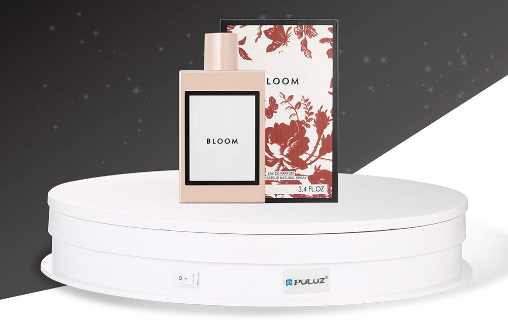 Na białej obrotowej podstawce znajduje się flakon perfum oraz pudełko z napisem \'BLOOM\'. Na podstawce widoczne jest logo \'Puluz\'.