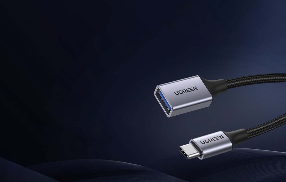 Na ciemnym tle widoczny jest adapter z dwoma końcówkami: USB-C i USB-A 3.0, z logo \'UGREEN\' na obu złączach.