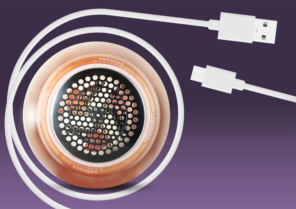 Golarka do ubrań NENO Merino Widok od spodu na stalowe ostrza golarki Neno otoczone białym kablem USB do ładowania na fioletowym tle.