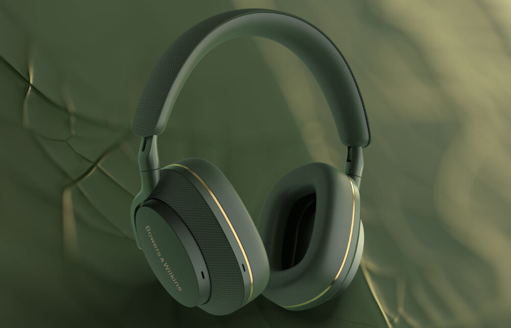 Zielone słuchawki nauszne z widocznym logo \'Bowers & Wilkins\' na nauszniku. Tło jest w odcieniach zieleni z delikatnym wzorem.