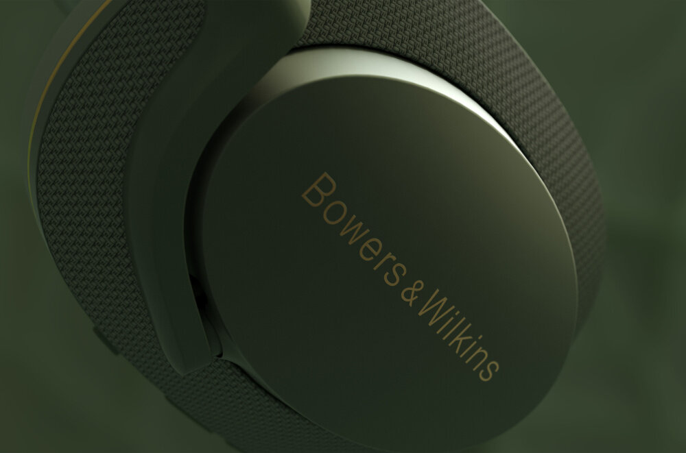Zbliżenie na zielone słuchawki nauszne z widocznym logo \'Bowers & Wilkins\' na nauszniku.