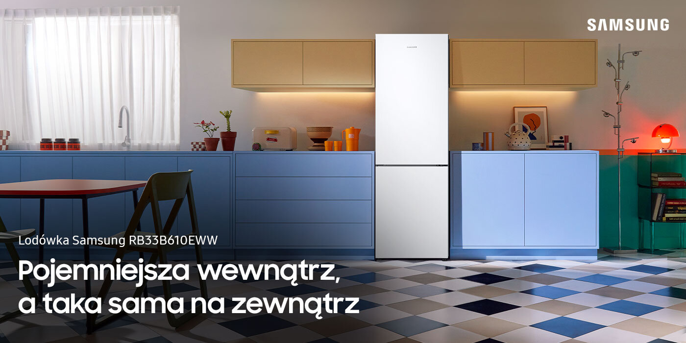 Kuchnia z białą lodówką Samsung RB33B610EWW, otoczona niebieskimi szafkami i kolorowymi dodatkami. Na obrazie widoczny jest tekst: \'Lodówka Samsung RB33B610EWW Pojemniejsza wewnątrz, a taka sama na zewnątrz\'.