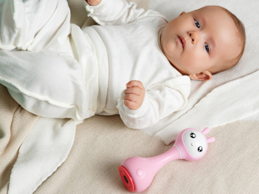 Zabawka edukacyjna ALILO Smarty Bunny R1 Niebieski wspiera wszechstronny rozwój dziecka, stymuluje zmysły dotyku i słuchu, interaktywne elementy, bogactwo dźwięków, rozwija koordynację wzroku i dłoni poprzez
zabawę w rozpoznawanie kolorów oraz interakcję z przyciskami, uczy samodzielności, funkcje w dwóch językach, pobudza twórczość muzyczną i zachęca do odkrywania nowych możliwości, dziecko leżące obok zabawki