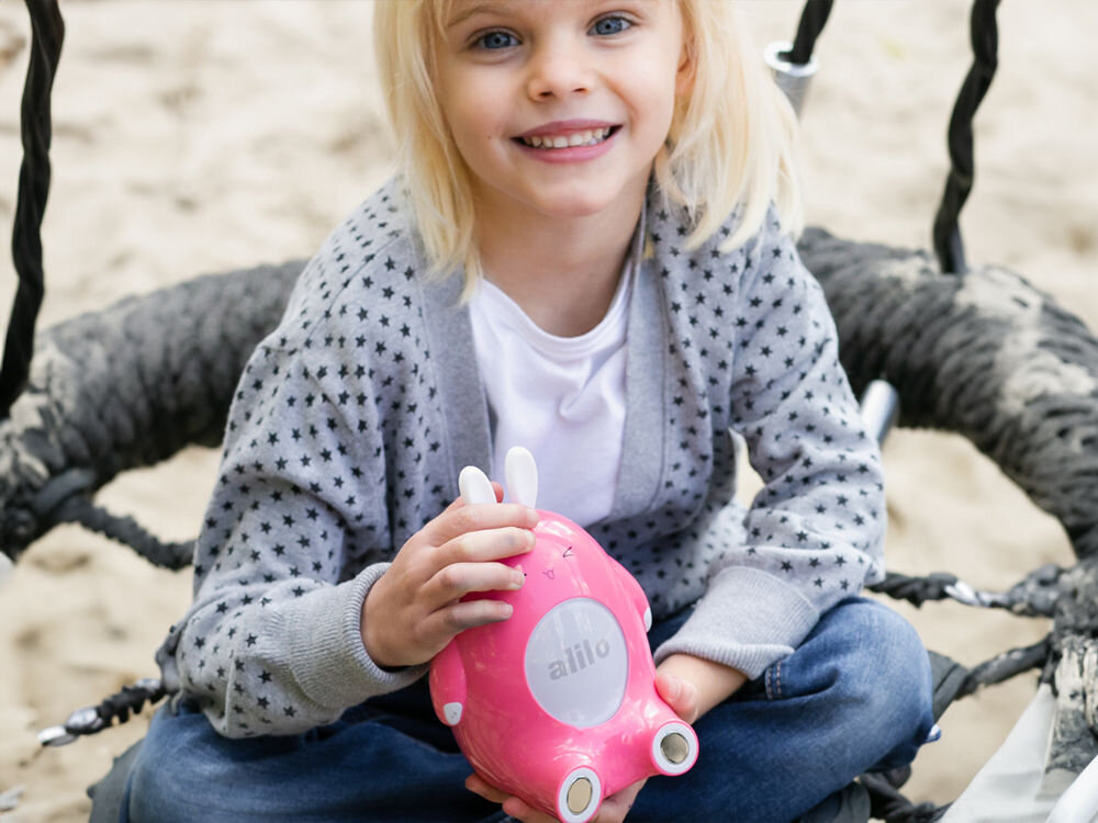 Zabawka edukacyjna ALILO Happy Bunny P1 Niebieski wspiera rozwój muzyczny, interaktywna zabawka, rozwija muzyczne zdolności dziecka, zachęca do zabawy motorycznej, możliwość wyboru zabaw
					rozwijających poczucie rytmu poprzez dotknięcie czoła króliczka, dziewczynka na huśtawce trzymająca produkt w wersji różowej