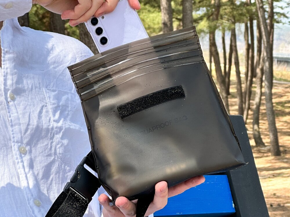 Wodoodporna torebka Araree Aquaproof Bag
            torebka w ręku wilgoć szczelność zamykanie ochrona