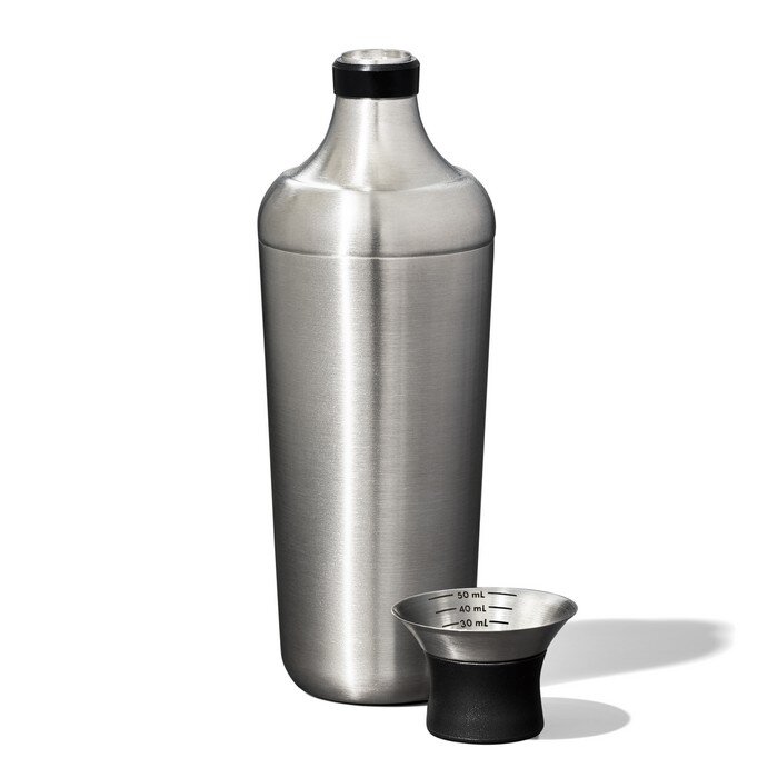 Na obrazie widoczny jest stalowy shaker z czarnym elementem na górze oraz miarka z oznaczeniami 30 mL, 40 mL i 50 mL. Oba przedmioty mają metaliczne wykończenie.