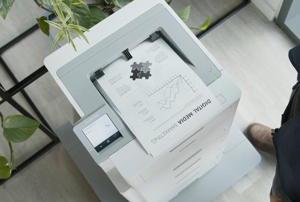 Drukarka BROTHER HL-L6410DN widok na drukarkę z góry, z wydrukami wychodzącymi z niej podajnik pojemność moduł zszywający odbiornik sortujący