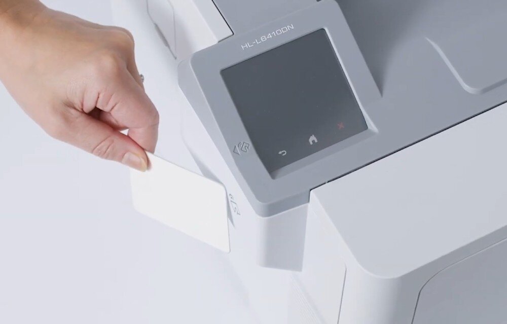 Drukarka BROTHER HL-L6410DN zbliżenie na dłoń trzymającą kartę i przykładającą ją do czytnika NFC drukarki łączność Ethernet sieć wyświetlacz