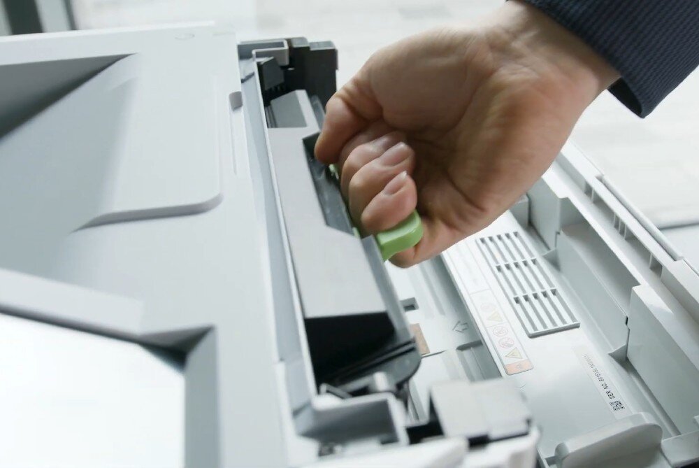 Drukarka BROTHER HL-L6410DN zbliżenie na dłoń wyjmującą wkład z tonerem z drukarki wydajność toner