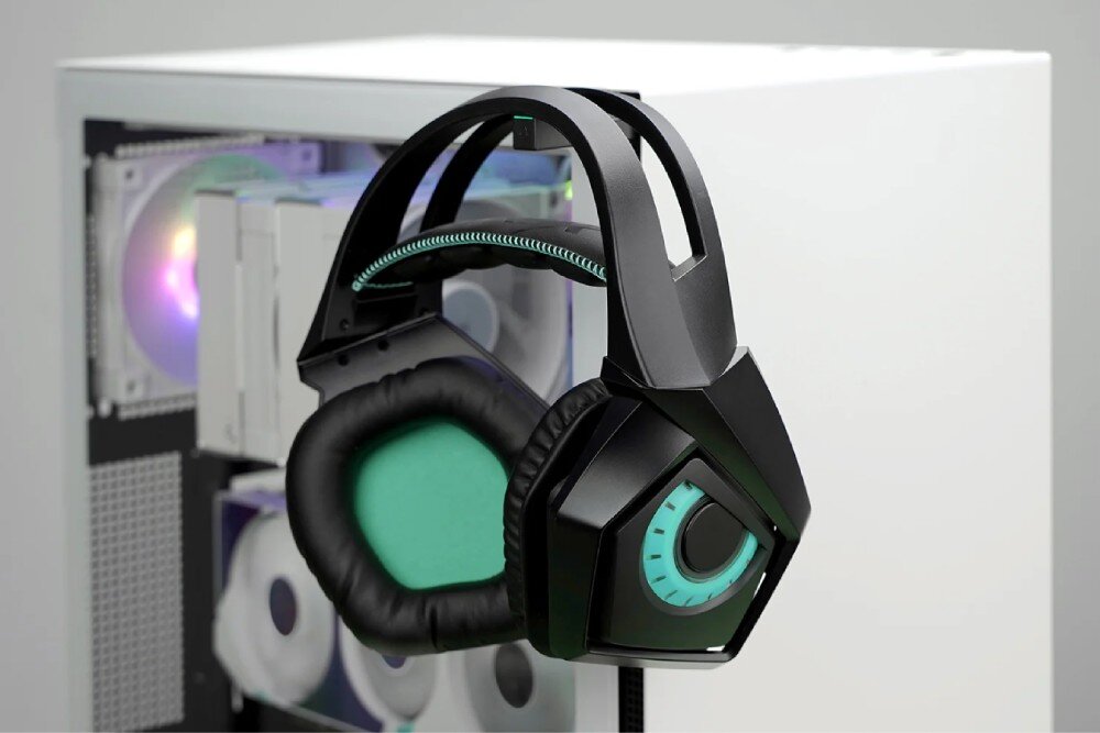 Obudowa DEEPCOOL CH510 Duże słuchawki nauszne zawieszone na wysuwanym uchwycie, który znajduje się na krawędzi przedniego panelu obudowy komputerowej. W tle przez szybę prześwitują podzespoły wewnętrzne