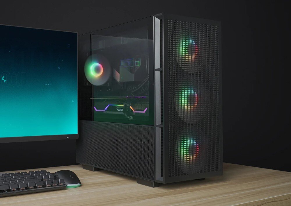 Obudowa DEEPCOOL CH560 Komputer stacjonarny w czarnej obudowie z przeszklonym bokiem stoi na drewnianym biurku obok monitora i klawiatury. Wewnątrz widoczne są podświetlone kolorowo komponenty oraz wentylator, a na przednim panelu trzy kolejne świecące wentylatory za siatką typu mesh