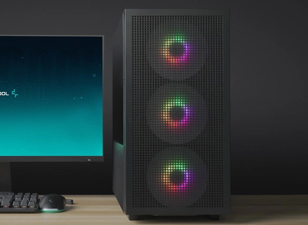 Obudowa DEEPCOOL CH560 Przedni panel czarnej obudowy komputerowej z gęstą perforacją, przez którą prześwitują trzy okrągłe wentylatory z wielokolorowym podświetleniem RGB. Obok stoi włączony monitor z turkusową tapetą