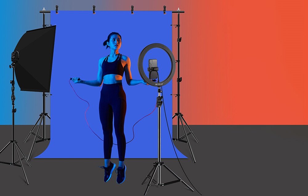 Dwie dziewczynki na tle zielonego ekranu chroma key w studiu; na monitorze widać efekt końcowy z podmienionym tłem.