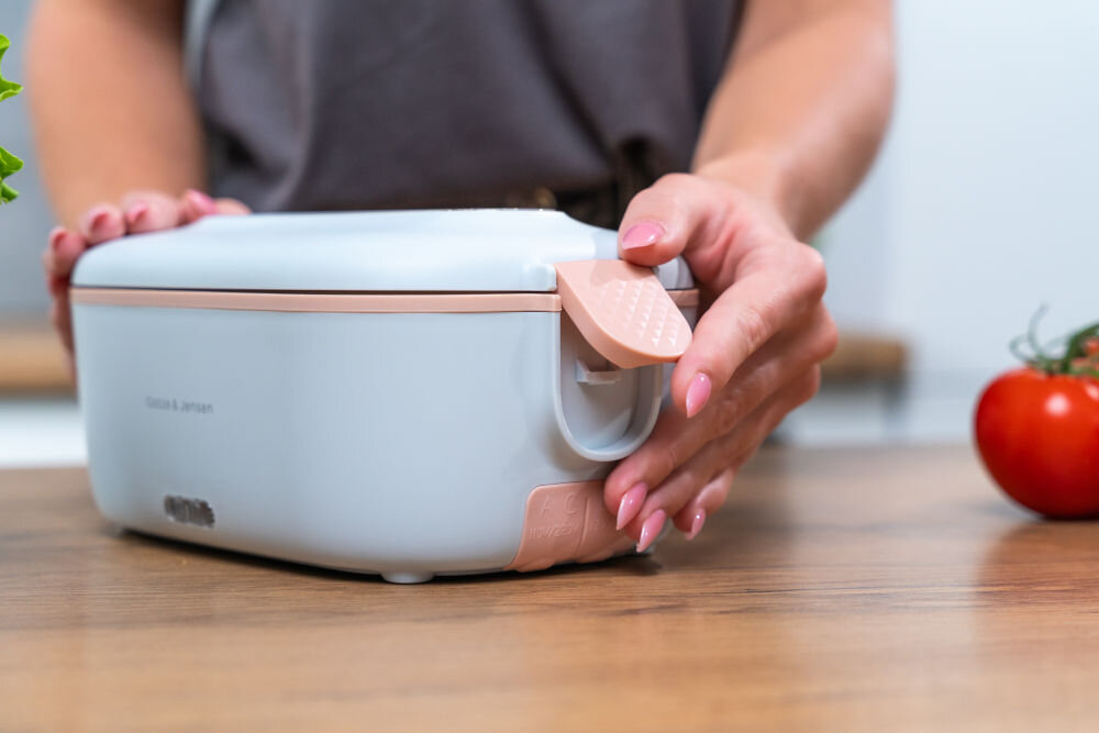 Lunch box GÖTZE & JENSEN KA130 Zbliżenie na boczny zatrzask i gniazda zasilania AC/DC w lunchboxie Götze & Jensen, umożliwiające podłączenie do sieci lub gniazda zapalniczki samochodowej.