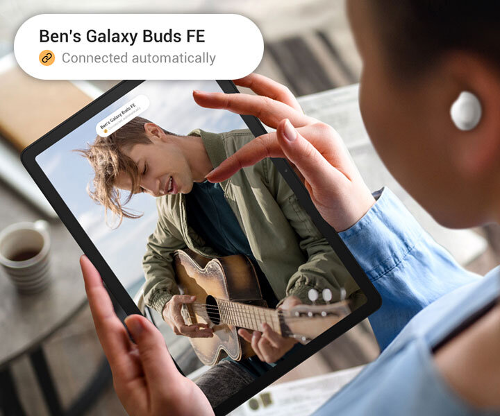 obrazek czwarty 100 Osoba używa Galaxy Tab A9+ ze słuchawkami Galaxy Buds FE. Na ekranie widać mężczyznę grającego na gitarze. Na górze wyświetlacza widoczne jest powiadomienie i powiększona wersja tego samego powiadomienia w lewym górnym rogu. Powiadomienie dotyczy słuchawek Buds Galaxy Buds FE, a następna linia posiada ikonę połączenia z tekstem Połączone automatycznie.