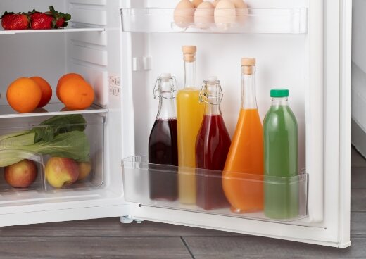 Zbliżenie na drzwi otwartej lodówki wypełnionej produktami.