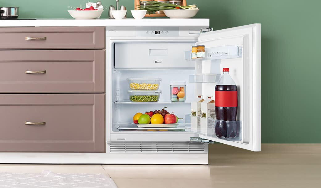 Otwarta lodówka MPM-116-CJI-17/E obok szafek kuchennych.