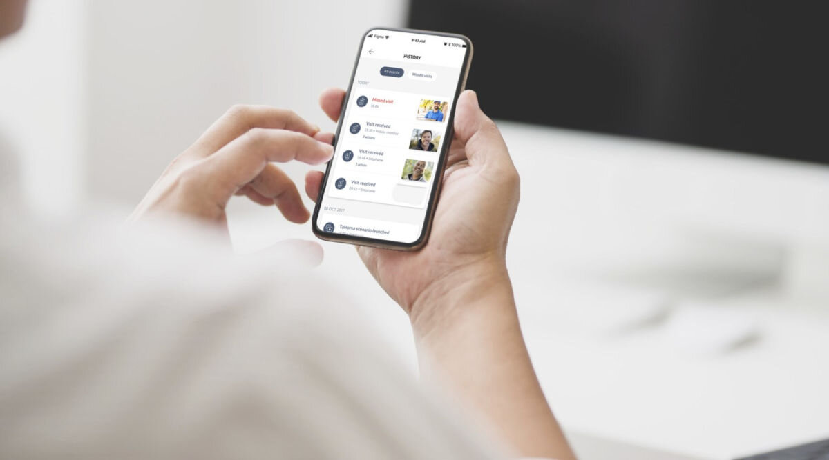 Moduł SOMFY 9028474 , zdarzenia, kurier,funkcjonalność, kontrola, osoba trzyma smartfon w rękach z włączoną aplikacją somfy