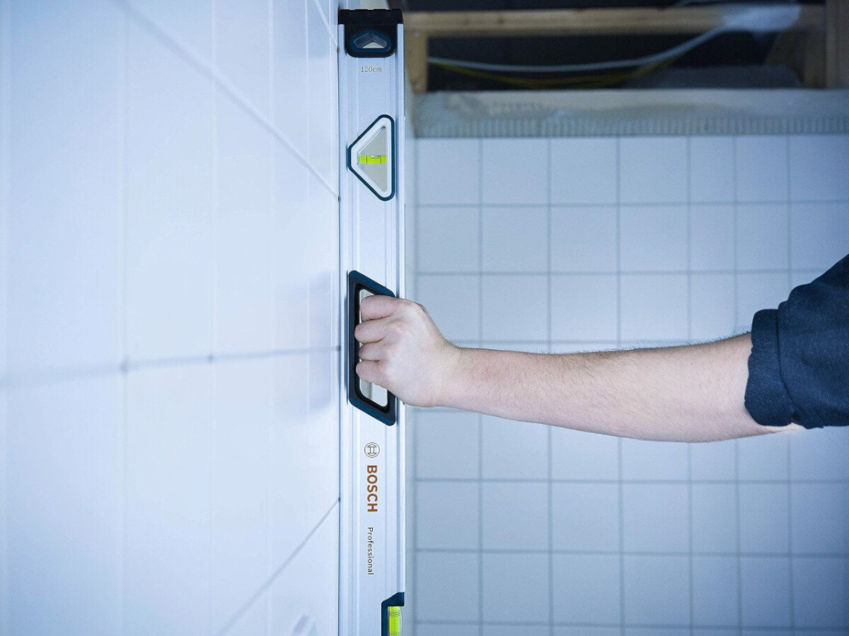 Poziomica BOSCH Professional 1600A016BR, poziomica, budowa, pomiar, prosta, poziomica przytwierdzona do ściany pionowej na budowie wyznacza pion