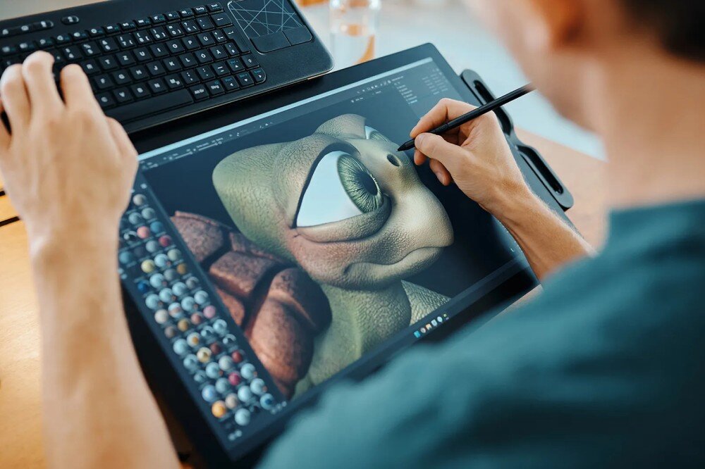 Tablet graficzny WACOM Cintiq Pro 17 Osoba rysuje na tablecie graficznym, na którym widoczny jest obraz żółwia z dużymi oczami. Obok znajduje się kolorowy pasek narzędzi z paletą kolorów, kolory dokładność głębia dostosowanie