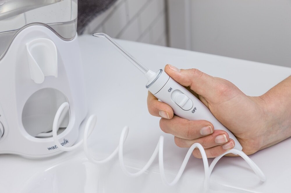 Irygator WATERPIK WP-160 Ultra Plus funkcja wstrzymywania strumienia wody, blokada strumienia wody, wygodny i łatwy sposób włączania i wyłączania