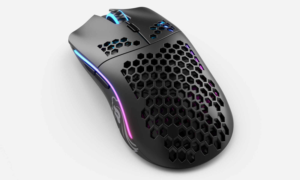 GLORIOUS PC Model O- Wireless Model O- symetryczna konstrukcja dłoni prawej, jak i lewej graczy leworęcznych - czarna mysz na białym biurku