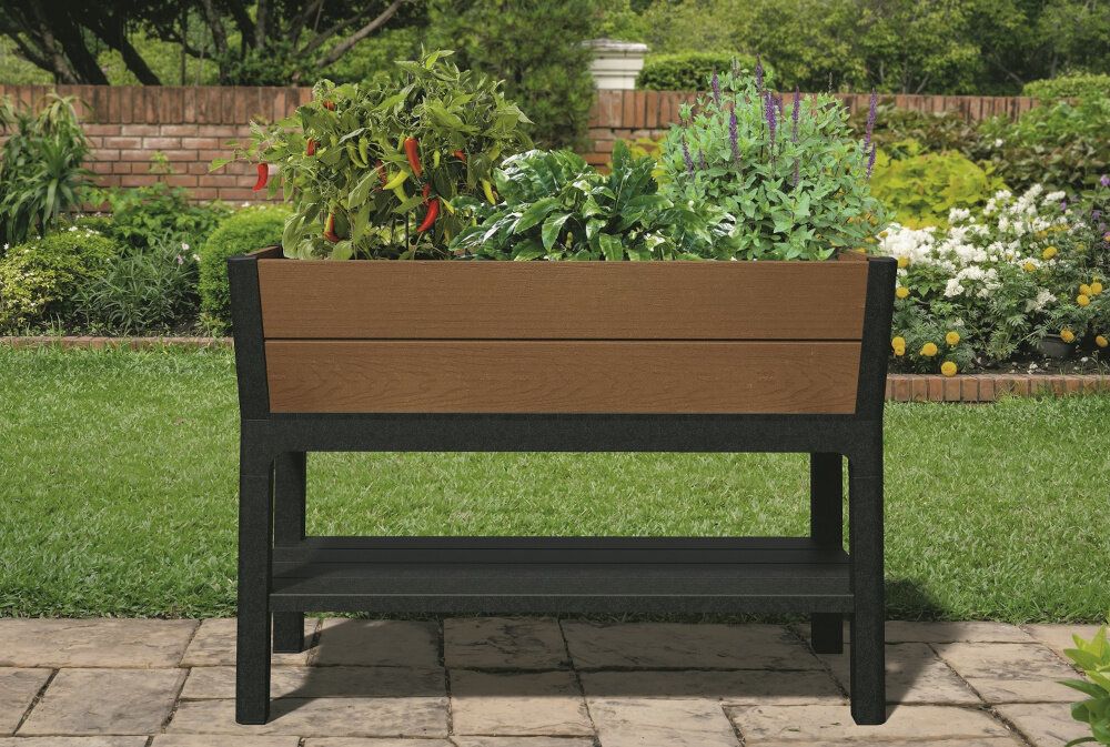 Donica KETER Elevated Garden Bed Pro 255161 110L Brązowy donica na tle roślin ustawiona na kamiennym podłożu wygodna uprawa roślin w ogrodzie na tarasie na balkonie pojemność 110 litrów podwyższona konstrukcja nogi pielęgnacja roślin bez konieczności schylania się wygoda porządek