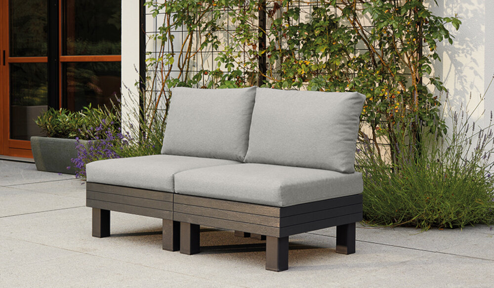 Sofa ogrodowa KETER 2 Elements 257365 Grafitowy sofa na tarasie w tle dom i rośliny elastyczne wyposażenie ogrodu relaks spotkania z rodziną znajomymi modułowa forma