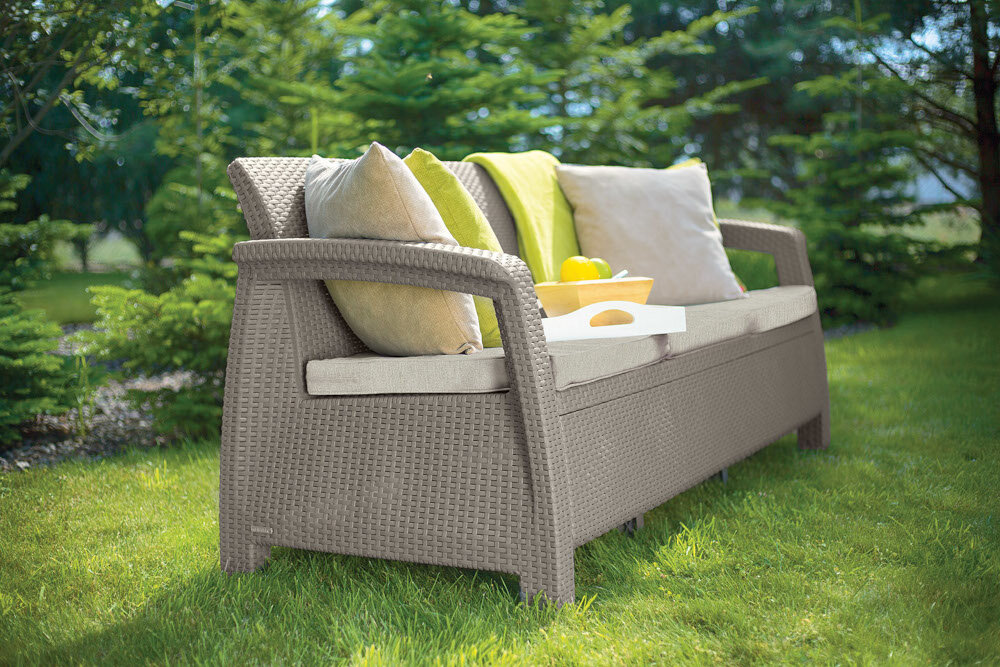 Sofa ogrodowa KETER Corfu II Max Love - OAT 258978 Cappuccino sofa na trawie w tle drzewa i rośliny 3-osobowa odpowiednia atmosfera na balkon taras do ogrodu kompatybilność z innymi elementami kolekcji KETER Corfu II Max Love - OAT 258978 wymarzony kącik do odpoczynku