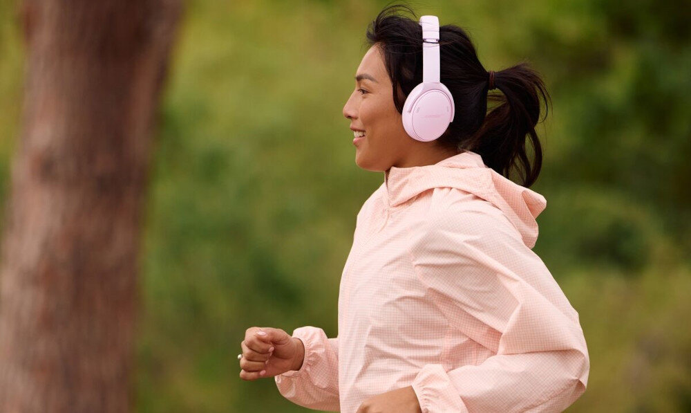 Słuchawki nauszne BOSE QuietComfort ANC Spotify Tap szybki dostęp do muzyki, osoba z założonymi słuchawkami nausznymi uprawiająca jogging