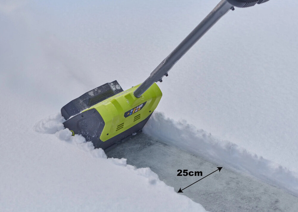 Odśnieżarka akumulatorowa RYOBI RY18ST25A-140 podwórko śnieg osoba odśnieża podłoże napis 25 cm szerokość odśnieżania wynosi 25 cm sprawne oczyszczanie wąskich przejść i ciągów komunikacyjnych praca przebiega szybciej i bardziej równomiernie ułatwia utrzymanie porządku