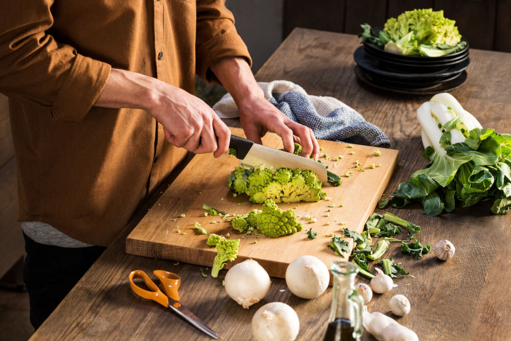 Nóż FISKARS Hard Edge 1051761 osoba kroi zielone warzywo na desce nożem z czarną rękojeścią dla każdego Ostrze o długości 16,1 cm całkowitej długości 29,1 cm krojenie siekanie waży jedynie 115 g