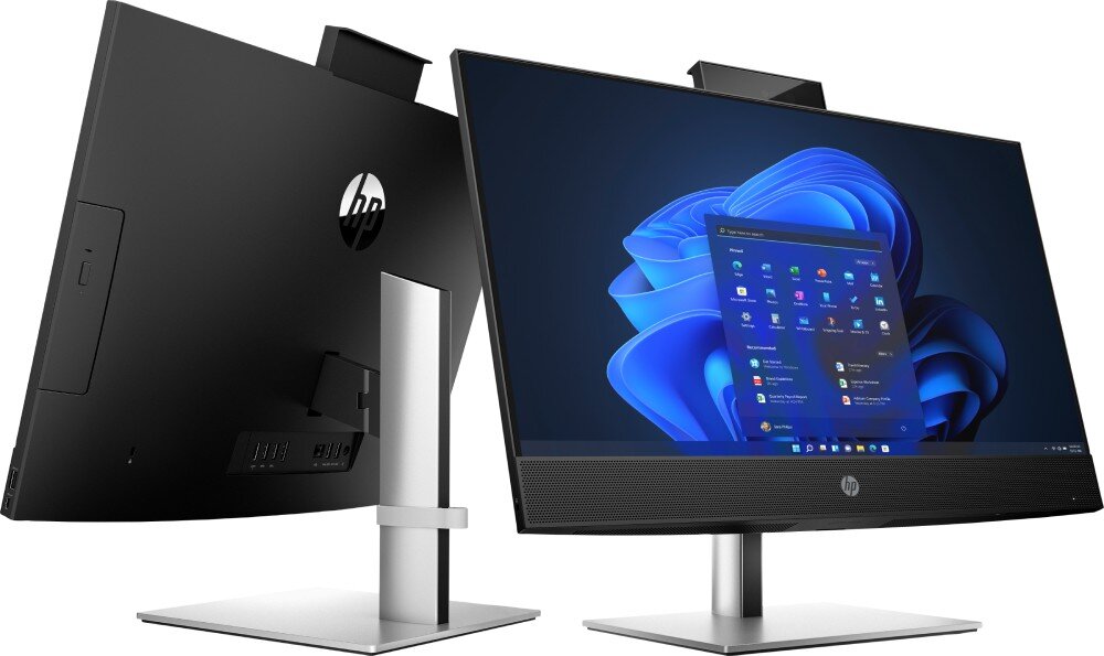 Komputer HP ProOne 440 G9 Dwa komputery typu All-in-One ustawione tyłem do siebie, widoczne smukłe obudowy i metalowe podstawy, na ekranach otwarty system operacyjny, porty, złącza, łączność