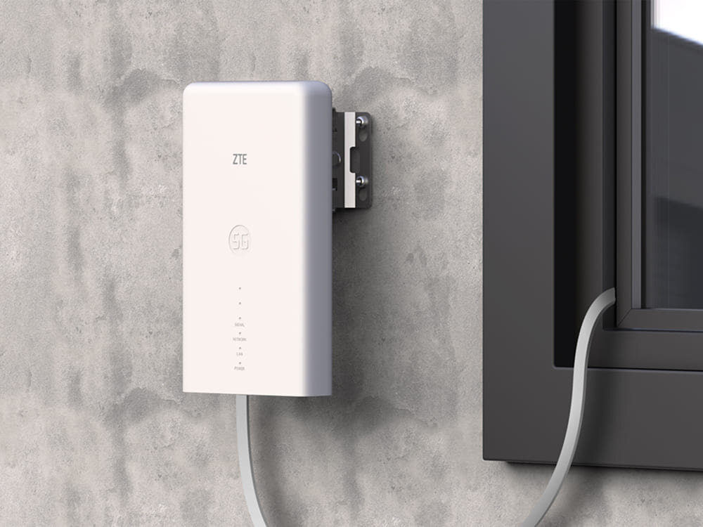 Router ZTE MC889 zamontowany na zewnętrznej ścianie budynku. Smukły design i podłączony kabel podkreślają nowoczesną technologię i łatwą łączność 5G, przeznaczenie, kompatybilność