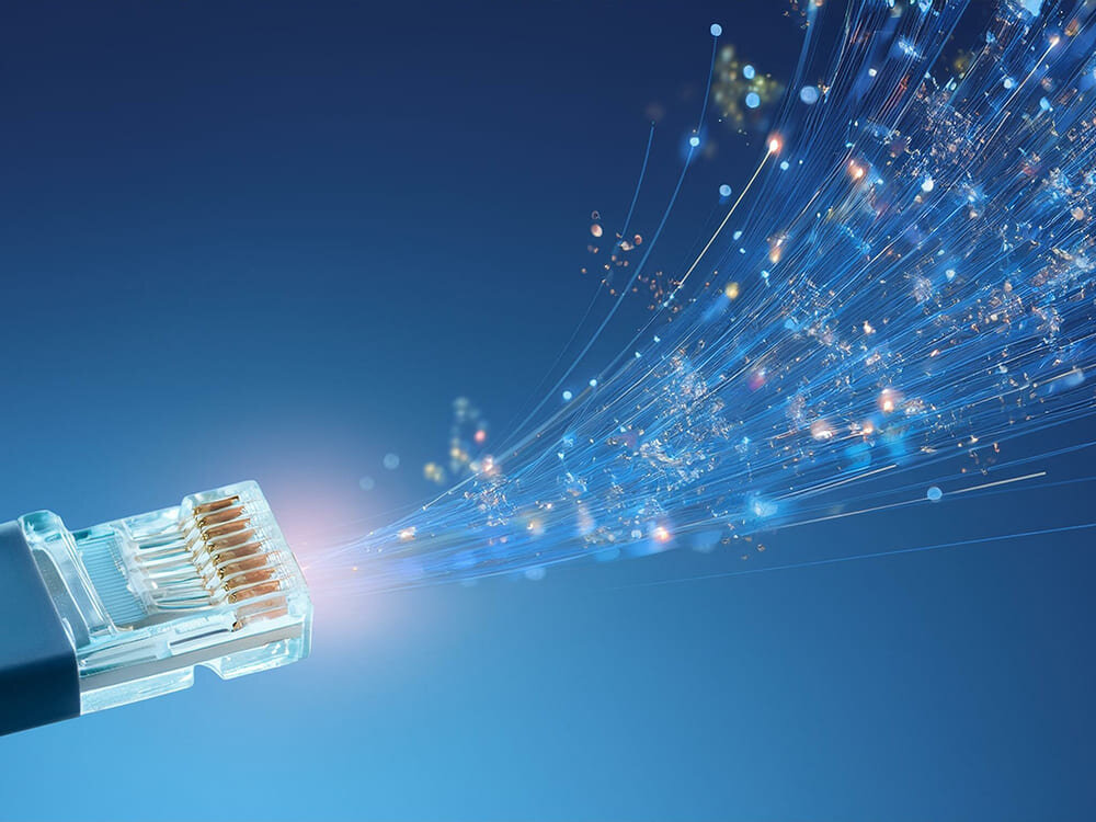 Kabel Ethernet świecący na niebiesko z włóknami światłowodowymi na ciemnoniebieskim tle. Obraz przedstawia szybki przepływ danych i stabilne połączenie sieciowe, wykonanie, złącza