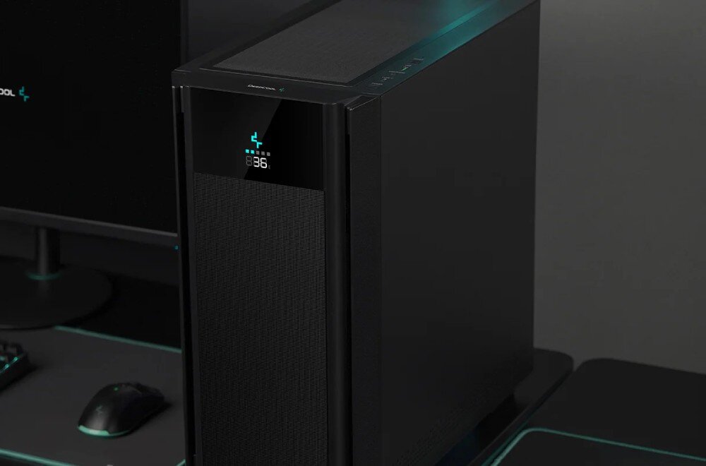 Obudowa DEEPCOOL CH510 Mesh Digital Czarna obudowa komputerowa typu mid-tower na ciemnym biurku obok monitora, pokazująca siatkowany front z małym ekranem oraz górną część z przyciskami