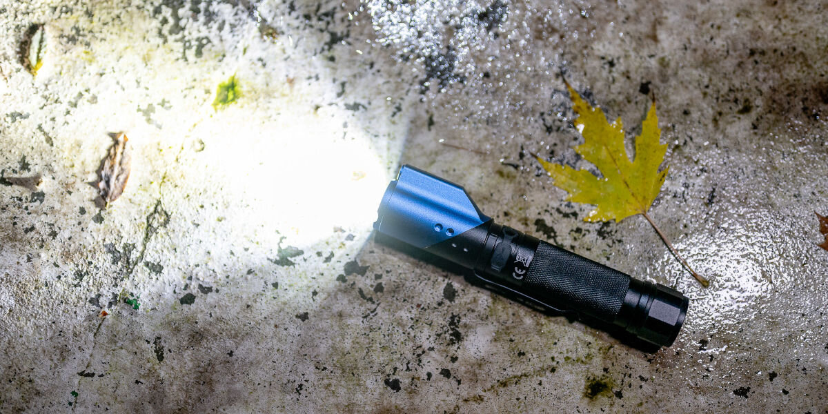 Latarka taktyczna NEWELL FL1000LUV USB-C z UV i laserem, akumulatorr, praca, świecenie, usb-c, Latarka Newell FL1000LUV leży zapalona